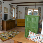 Living area with tiled stove-holiday house Astrid